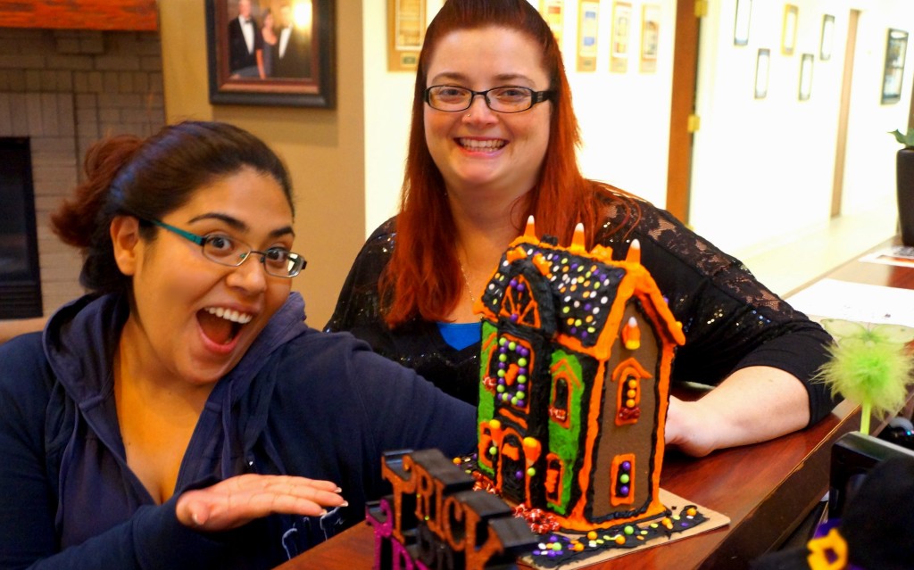 Carmen and Tina pose by the Completed Gingerbread House